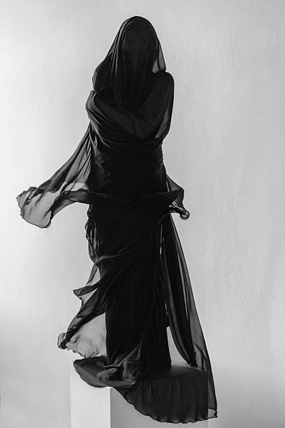 Mystical Figure Draped in Flowing Black Fabric on a Minimalist Background