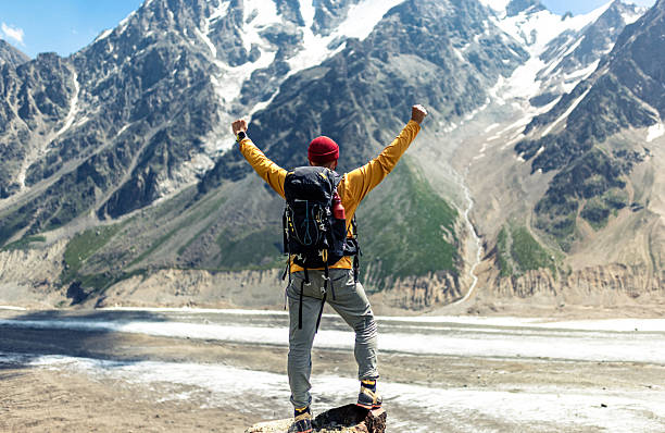 istock Triumphant Hiker Standing on a Mountain Overlooking a Stunning Snowy Valley 2235766508