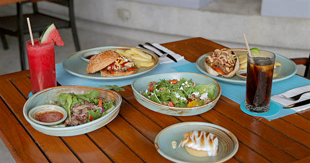 Cafe table setting with gourmet burgers, fries, fresh salads,