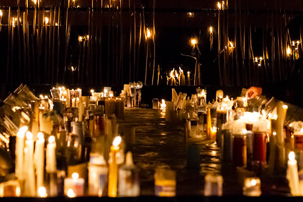 The photograph is taken in low light, highlighting the warm glow of the flames in contrast to the dark background. The central focus is on the candles, creating a depth of field that guides the eye to the back of the oratory.The use of candles in religious contexts is an ancient practice present in various traditions, from Catholicism to Candomblé.Candles represent requests, thanksgiving, and hopes placed in the sacred.