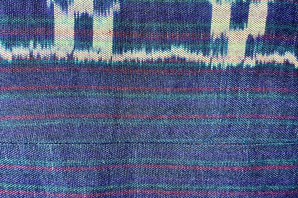 Handwoven ikat textile featuring colorful geometric patterns. Perfect for backgrounds, fashion, interior design, and cultural themes.