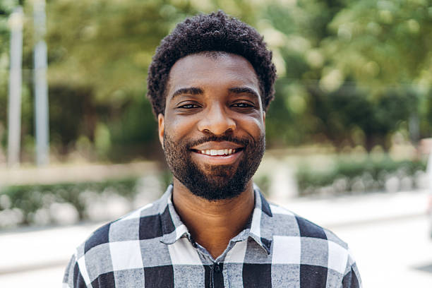 istock Young African American man smiling outdoors in urban park setting 2235777169