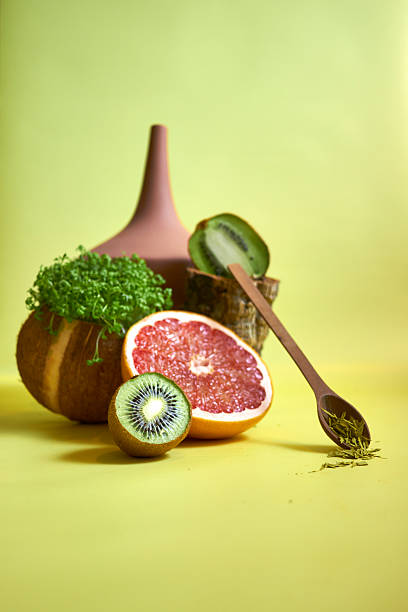 Creative still life with exotic fruits and vegetables arranged in artistic composition on yellow background. Minimalist style, healthy eating, organic food, modern art concept
