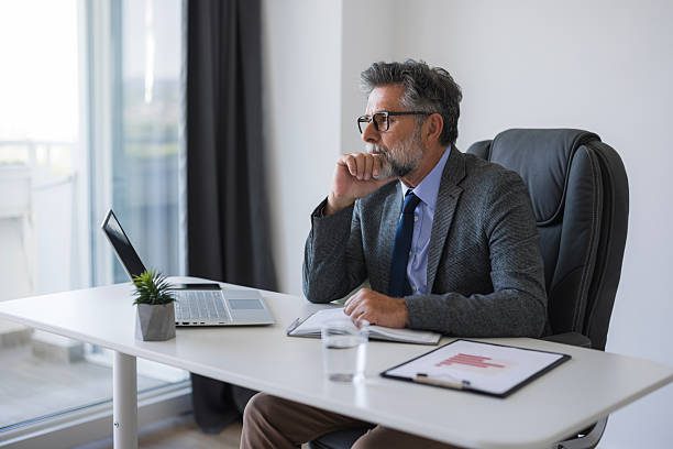 istock Pensive businessman working in modern office looking away 2235777434