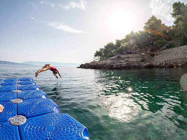 istock Woman Diving Off Floating Dock into Sea 2235780743