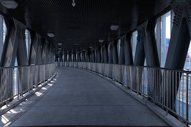 istock Curved walkway with metal framework and urban view in bright daylight 2235781484