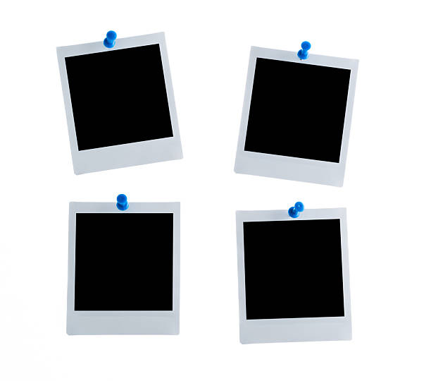 istock Four blank instant camera photo prints with blue pushpins on white background 2235784772
