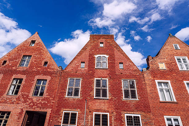 A charming architectural view of traditional brick facades in the Dutch Quarter of Potsdam, Germany, against a bright, clear sky, showcasing historical European design and cultural heritage landmarks.