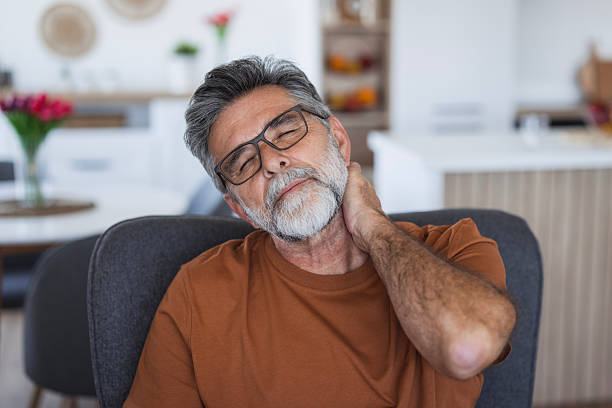 istock Mature man suffering from neck pain at home 2235793859