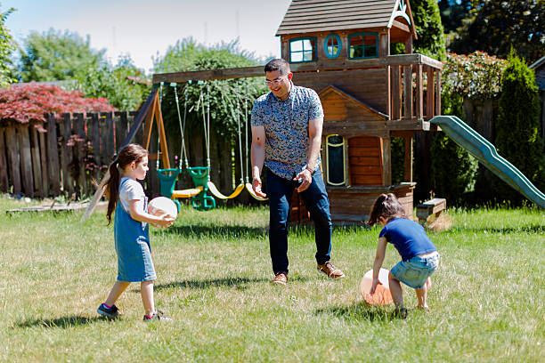 istock Latino Father and daughters Playing Together in backyard on a sunny day 2235794680