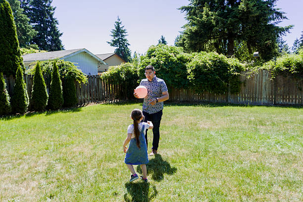 istock Latino Father and daughters Playing Together in backyard on a sunny day 2235794711