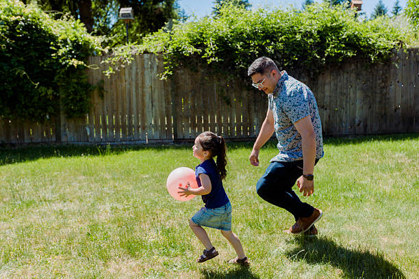 istock Latino Father and daughters Playing Together in backyard on a sunny day 2235794833
