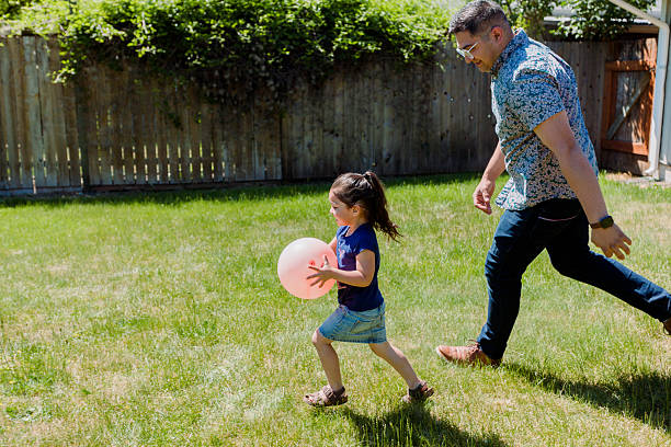 istock Latino Father and daughters Playing Together in backyard on a sunny day 2235794838