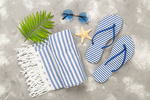 istock Beach towel with summer accessories on concrete background, top view 2235795250