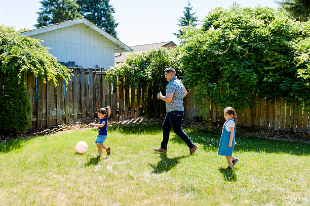 istock Latino Father and daughters Playing Together in backyard on a sunny day 2235795331