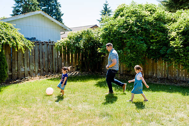 istock Latino Father and daughters Playing Together in backyard on a sunny day 2235795376