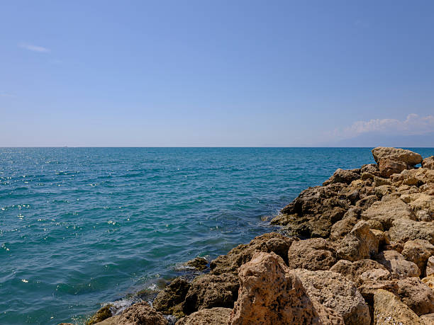 Calm ocean waves by beach rocks