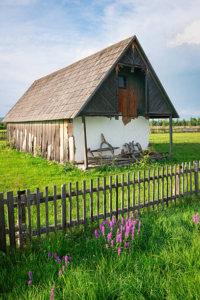 istock Rustic barn with wooden fence surrounded by lush green fields 2235796723