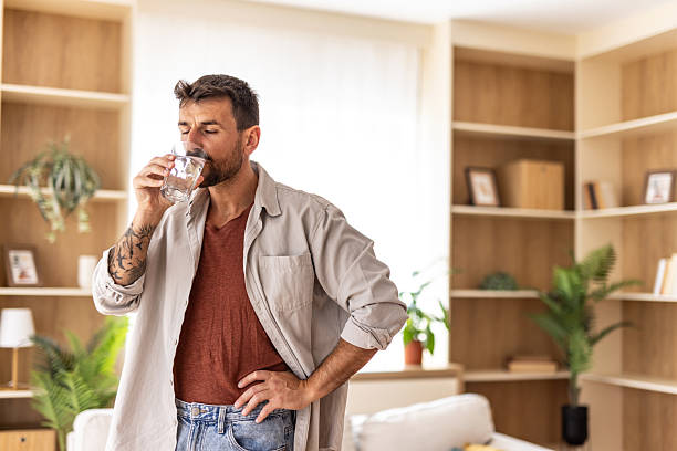 istock Mid adult man drinking water at home 2235798669