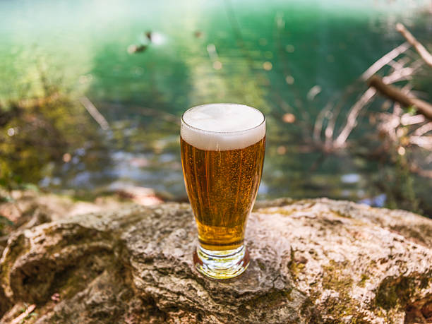 istock Cold glass of beer while camping by the lake 2235798852