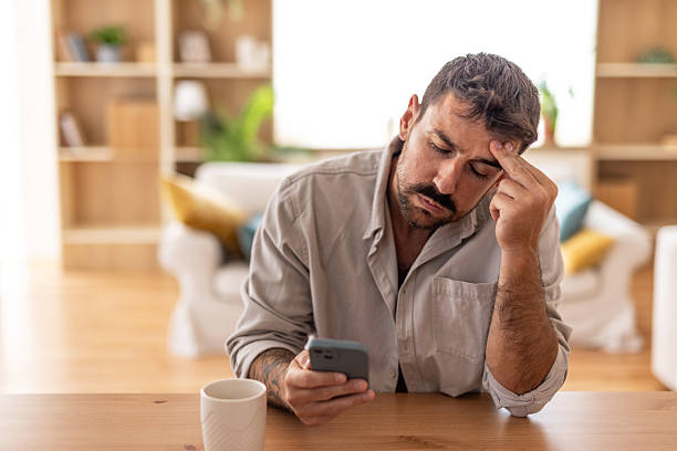 istock Stressed man reading bad news on smartphone at home 2235799025
