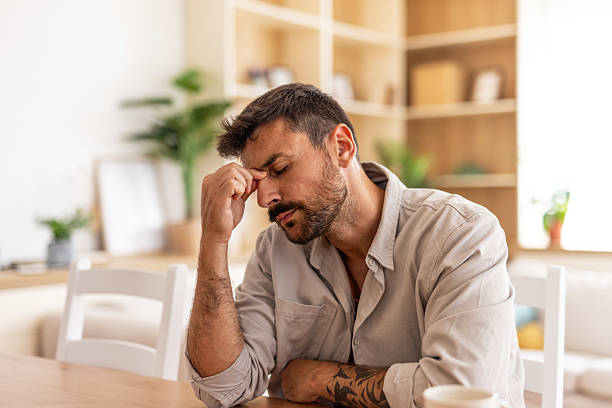 istock Stressed man suffering from headache at home 2235799098