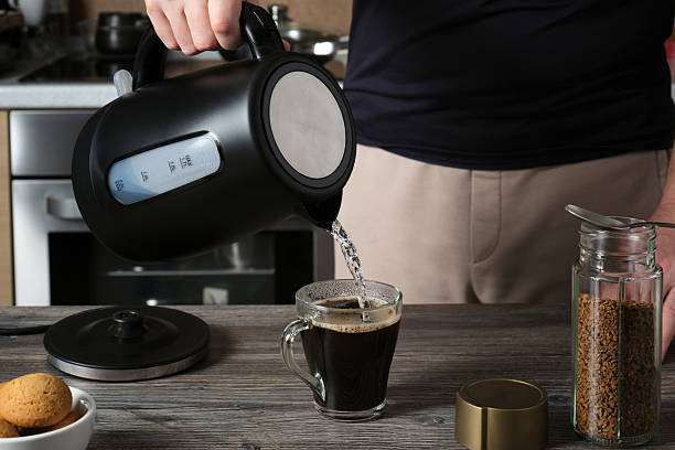 istock A man prepares aromatic instant coffee in a glass cup in his home kitchen. 2235800194