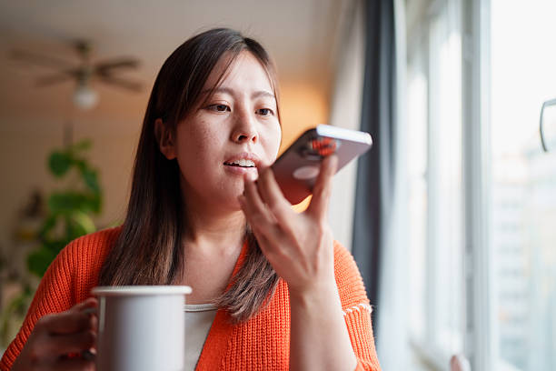 istock Woman using voice assistant on smartphone while holding mug 2235801288