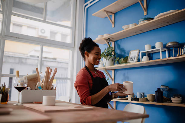 istock Black Woman Arranging Handmade Clay Items in Her Pottery Studio 2235803268
