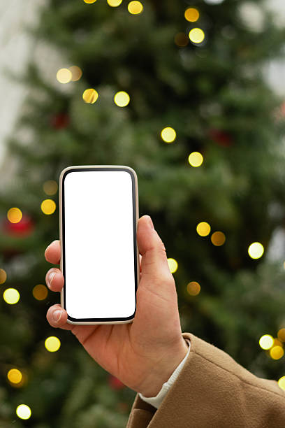 istock Man hand with smartphone near Christmas tree light garland. 2235803407
