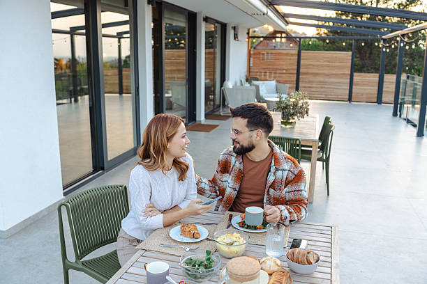 istock Couple enjoying breakfast together outdoors on a sunny patio 2235811044