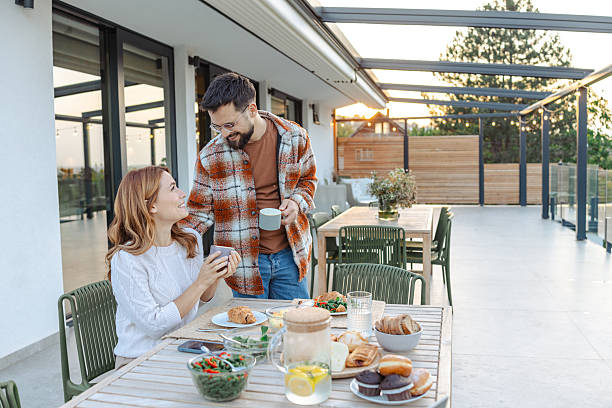 istock Couple enjoying breakfast on a modern terrace during a sunny morning 2235811314