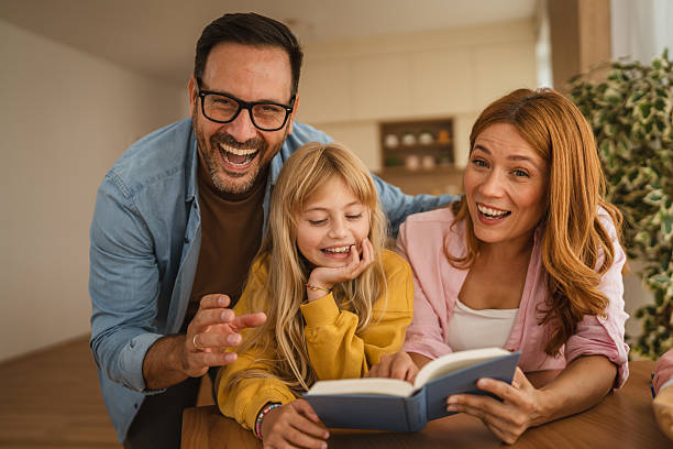 istock Happy family reading a book and having fun together 2235813245