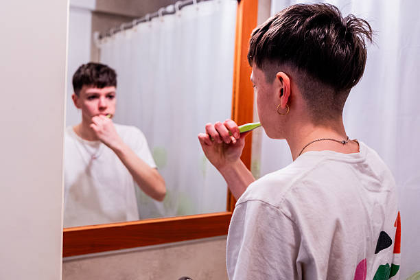 istock Young LGBTQIA+ woman brushing teeths at bathroom 2235814657