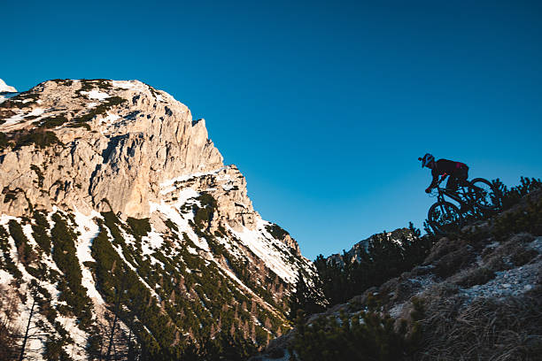 Female mountain biker descends steep mountain slope