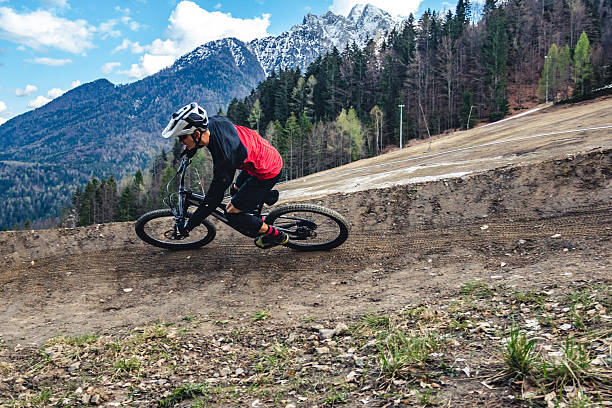Young man mountain bikes along flow track