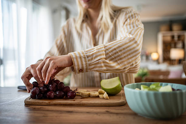 istock Woman preparing fresh fruit salad in the kitchen 2235819628