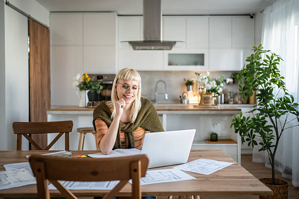istock Architect working from home on her laptop and smiling 2235820597