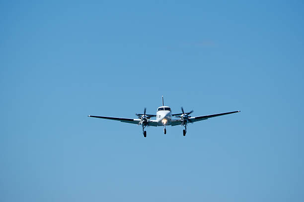 istock Small propeller plane flying in the blue sky on a sunny day. Twin-engine plane soaring through a clear blue sky. 2235824950