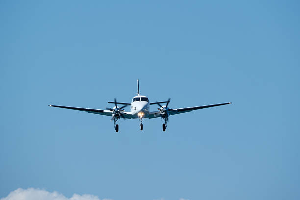 istock Small propeller plane flying in the blue sky on a sunny day. Twin-engine plane soaring through a clear blue sky. 2235824968