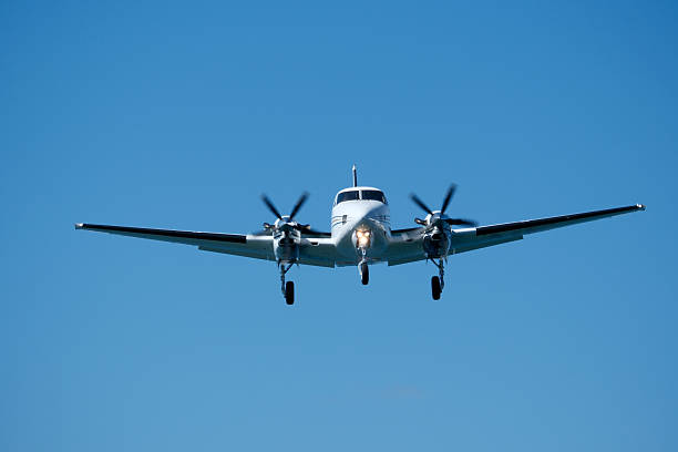 istock Small propeller plane flying in the blue sky on a sunny day. Twin-engine plane soaring through a clear blue sky. 2235825057