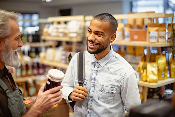 istock Friendly Interaction Between Smiling Multiracial Male Customer and Grocery Store Worker 2235826845