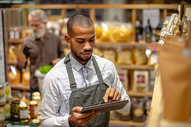 istock Professional Grocery Store Worker Using Digital Tablet For Inventory Management In Specialty Food Shop 2235826858