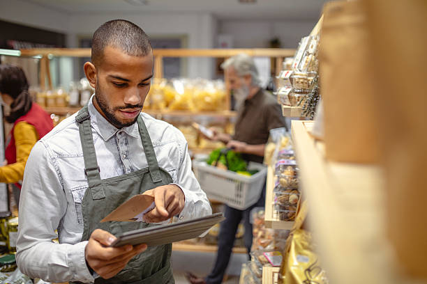 istock Focused Multiracial Male Grocery Worker Using Digital Tablet in Store Aisle 2235826859