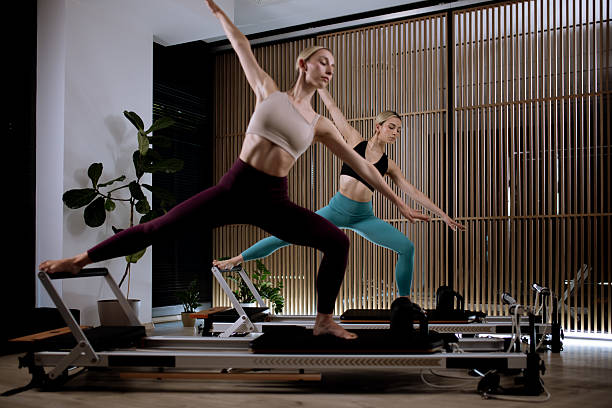 istock Two women practicing Pilates on reformer machines in a modern studio with natural light during a fitness class 2235826965