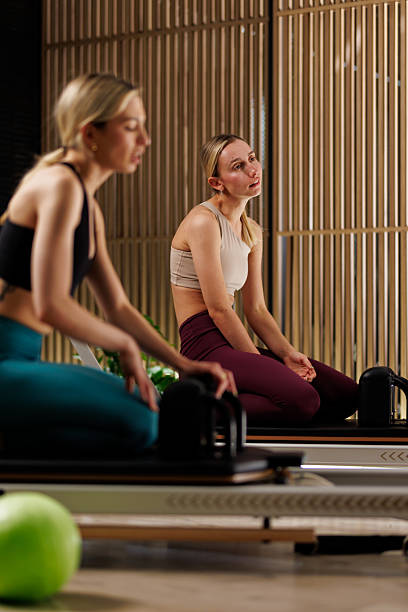 istock Women practicing pilates in a serene studio, focusing on posture and breath during an afternoon class with wooden decor 2235827016