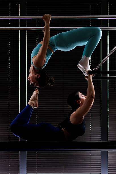 istock Two acrobats perform a stunning human sculpture in a studio against a backdrop of dark blinds during a daylight practice session 2235827216