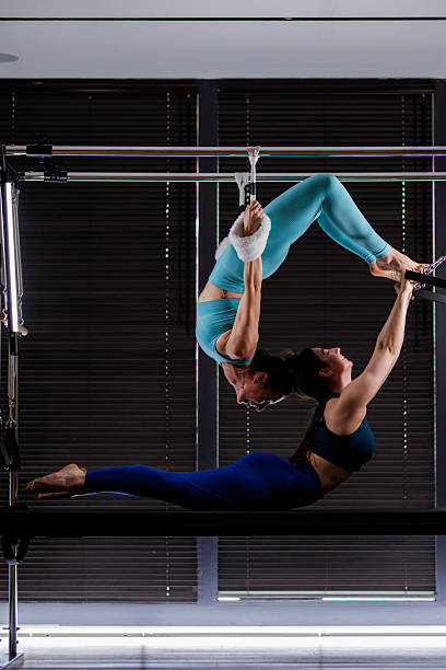 istock Two acrobats perform a stunning aerial fitness routine in a modern studio with large windows on a bright day 2235827549