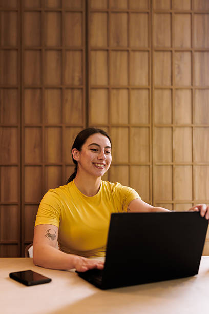 istock Woman working on laptop in modern workspace, showcasing focus, creativity, and a bright mood during daytime hours 2235827644