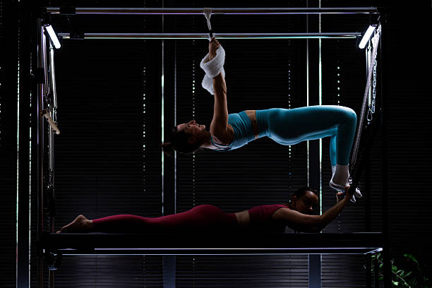 istock Two women practice advanced pilates exercises in a dimly lit studio to improve strength and flexibility during an evening training session 2235827668